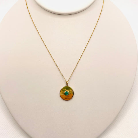 gold disc with emerald