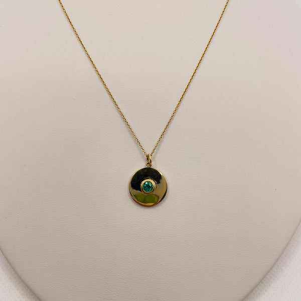 gold disc with emerald