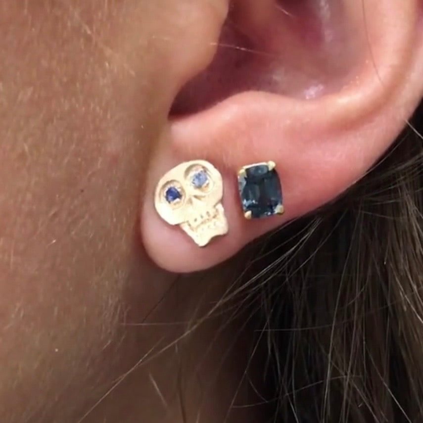 hand carved 18k gold skull earrings with sapphire eyes