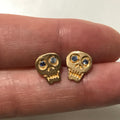 hand carved 18k gold skull earrings with sapphire eyes