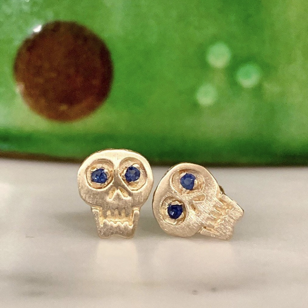 hand carved 18k gold skull earrings with sapphire eyes
